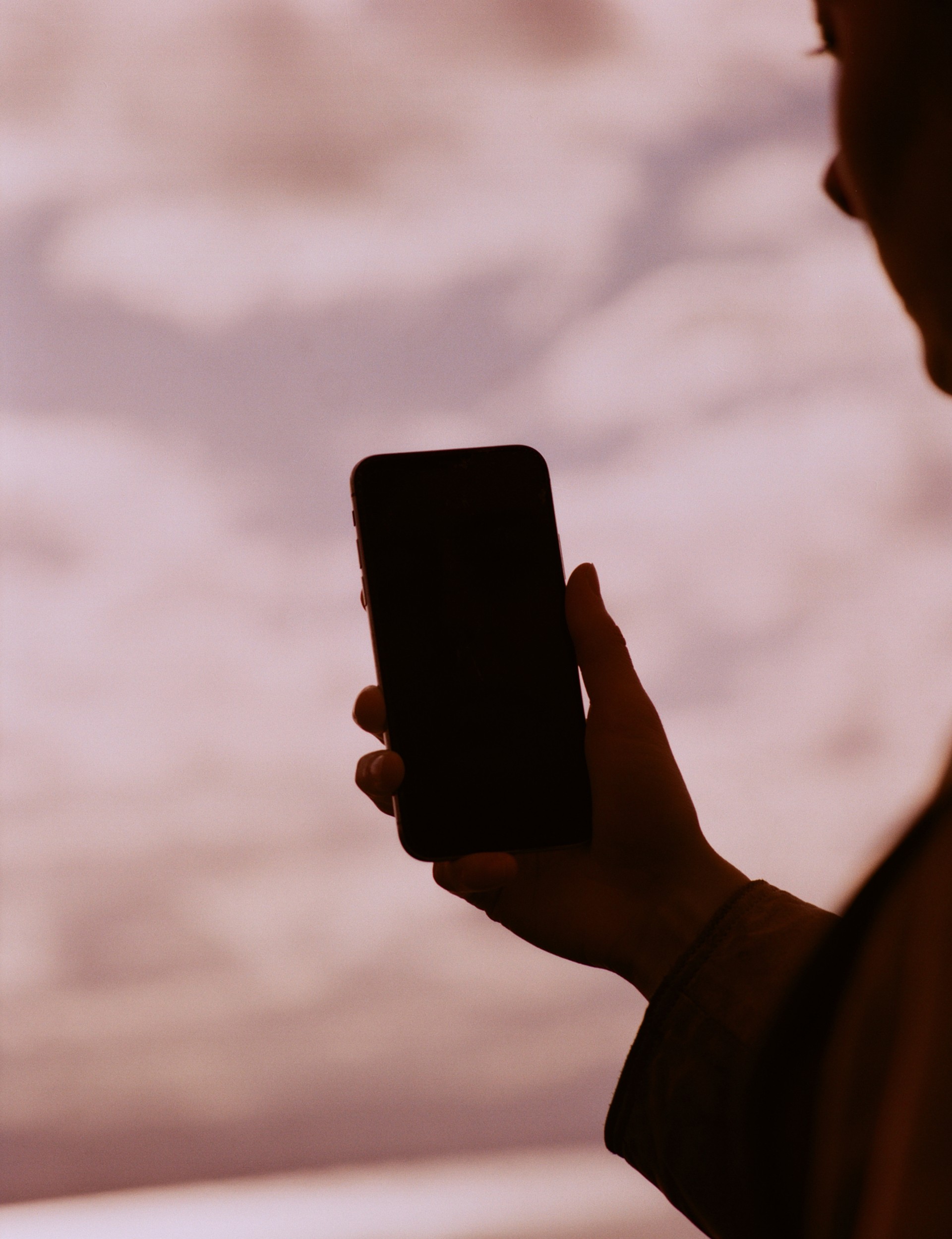 A silhouette of a person holding a phone